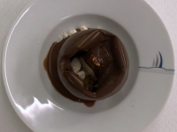 Dessert Schokoladekugel mit Mangogelee mit heisser Schokosauce