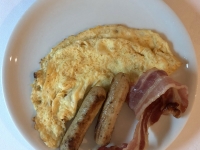 Frühstück serviert Omelette mit Würstchen und Frühstücksspeck
