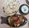 Tandoori Chicken auf heißer Platte mit Joghurt und Naan Fladenbrot für Gerald